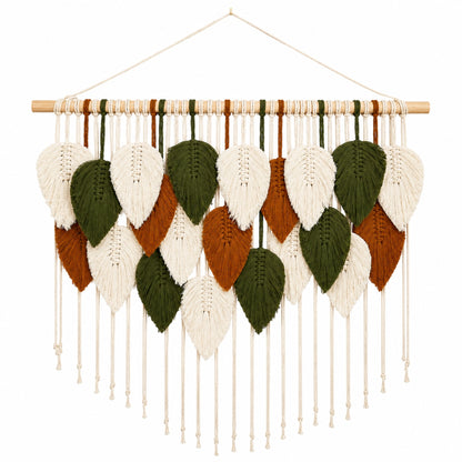 A hand-knotted macramé wall hanging featuring woven leaf shapes in white, olive green, and terracotta brown, suspended from a light wood dowel with a hanging string.