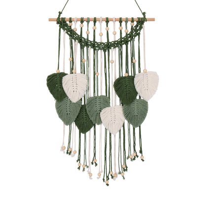 A bohemian-style macrame wall hanging with a natural wood dowel, green and white woven cords, and leaf-shaped ornaments, shown against a plain white background.