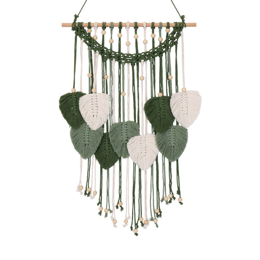 A bohemian-style macrame wall hanging with a natural wood dowel, green and white woven cords, and leaf-shaped ornaments, shown against a plain white background.